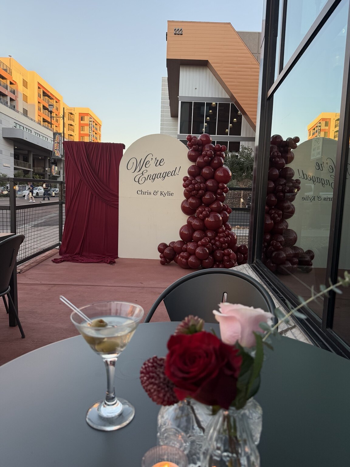 Full engagement party design with burgundy balloons, florals, backdrop, and tablescape