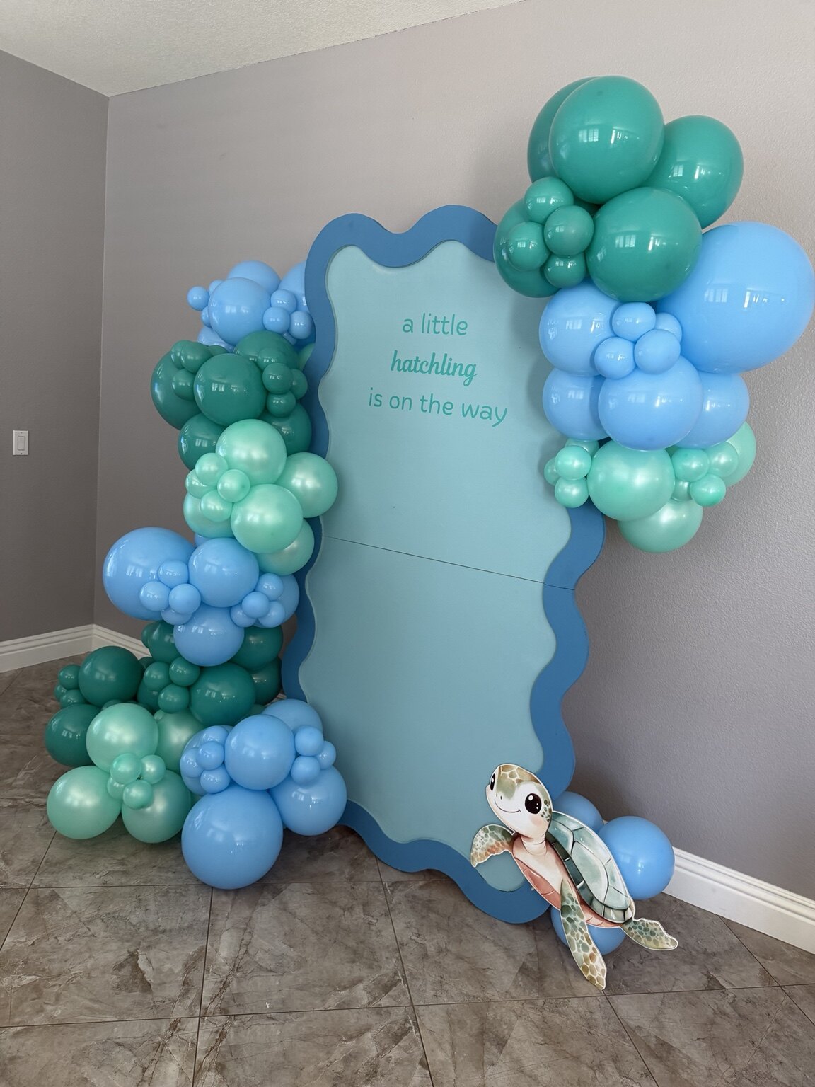 Blue and seafoam turtle baby shower backdrop with organic balloon garland